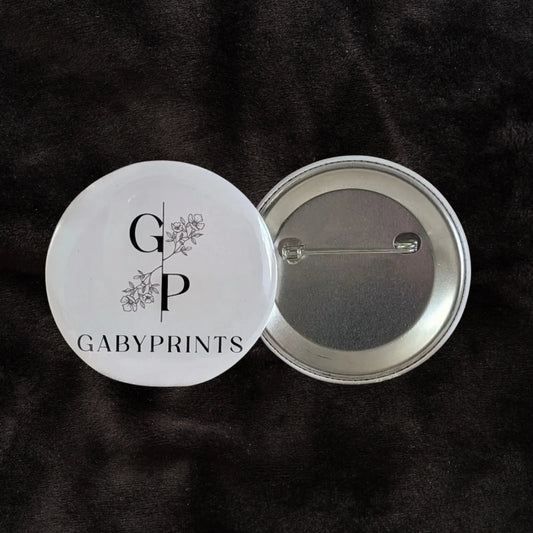 Macaron promotionnel blanc à l'effigie de GabyPrints sur tissus noir – White promotional button featuring GabyPrints on black fabric